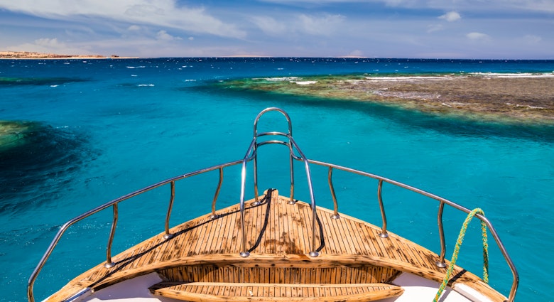 Cruise boat in the clear water near coral reef.